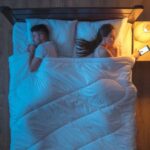 Paar im Bett mit Lichtwecker